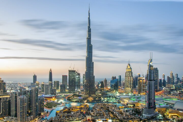 Experience the stunning skyline of Dubai highlighted by the iconic Burj Khalifa as the city transitions from day to night showcasing a blend of modern architecture and rich heritage.